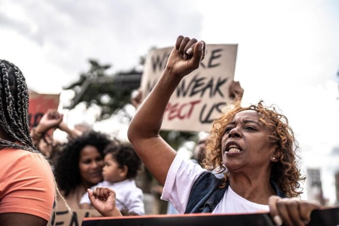 A group of people protesting Description automatically generated