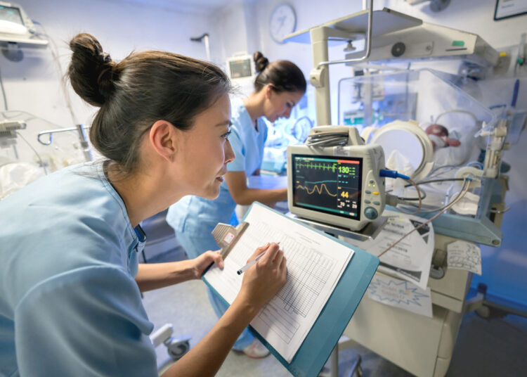 A person writing on a clipboard Description automatically generated