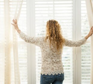 woman standing next to the windows