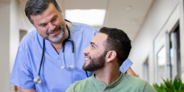 A doctor and patient looking at each other Description automatically generated with low confidence